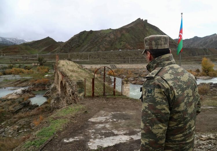    An Azeri service member looks at the ancient Khodaafarin Bridge near the border with Iran in the area, which came under the control of Azerbaijan's troops following a military conflict over Nagorno-Karabakh against ethnic Armenian forces and a further signing of a ceasefire deal, in Jabrayil District, December 7, 2020. Picture taken December 7, 2020. REUTERS/Aziz Karimov David Harutunov