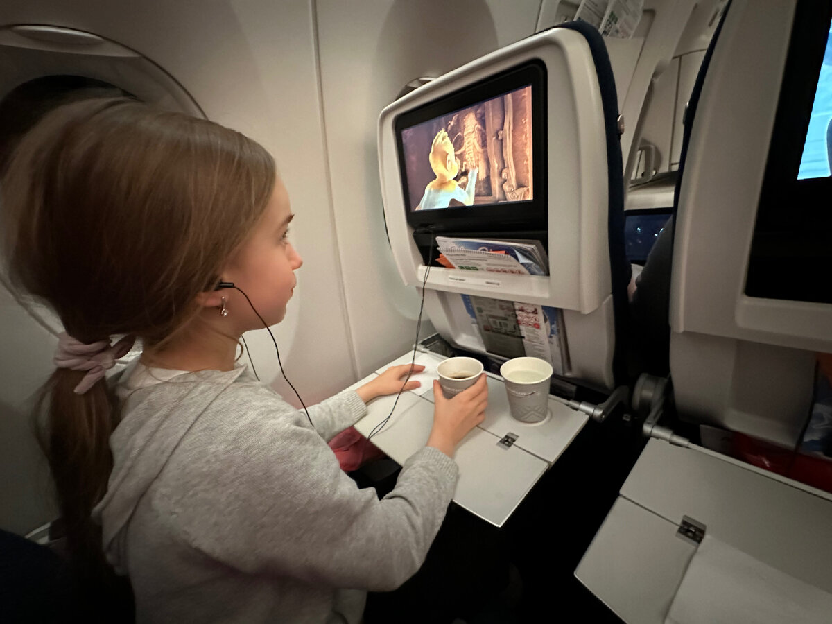 Дочка смотрит мультики во время полета Москва-Бангкок