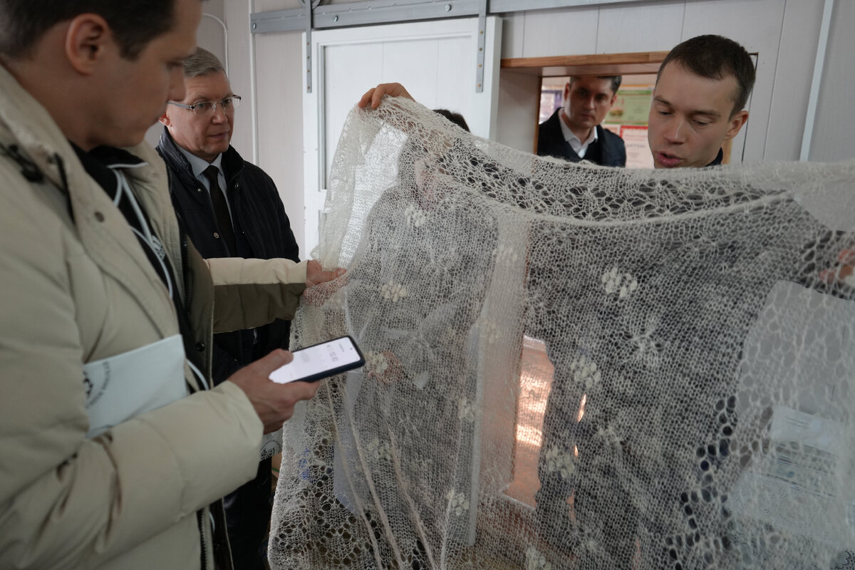 Руководитель компании "ОренбургШаль" демонстрирует гостям типичную подделку под оренбургский пуховый платок