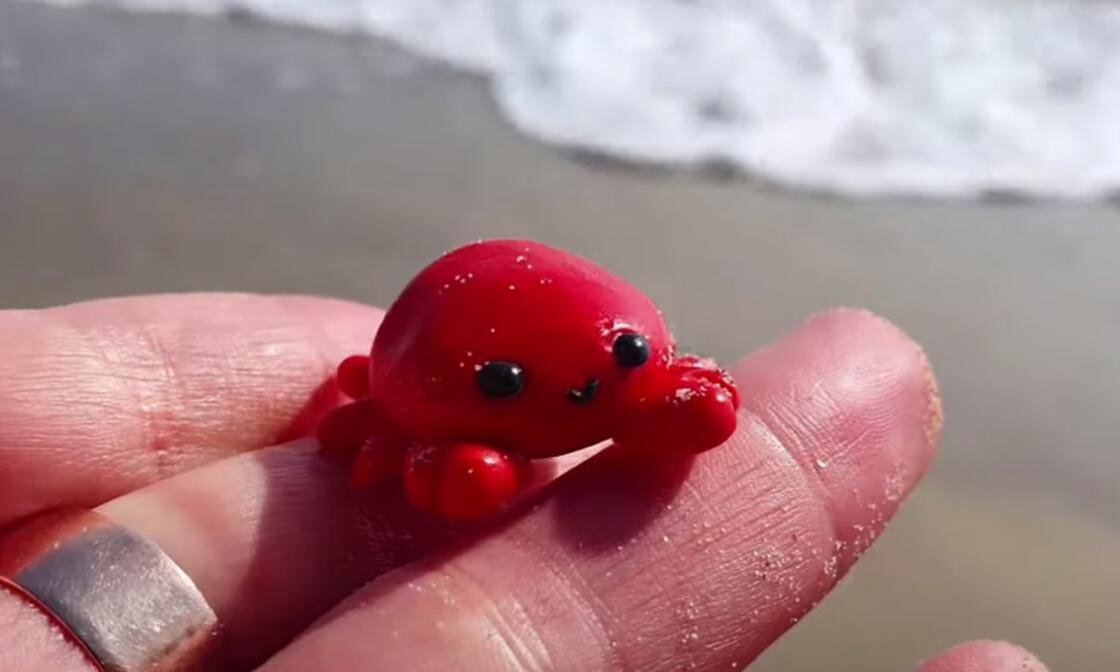    На руке держат красного краба из воздушного пластилина:YouTube/Юлия Назарова