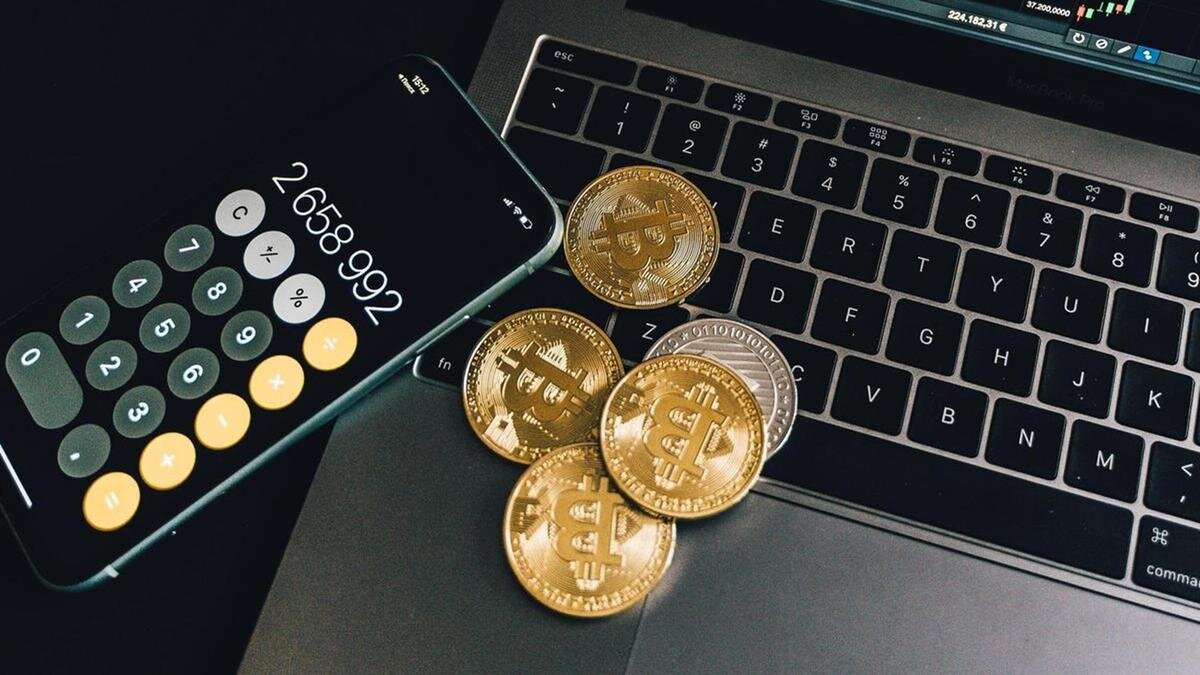    Монеты "Биткоин", смартфон и ноутбук лежат на столе:pexels.com