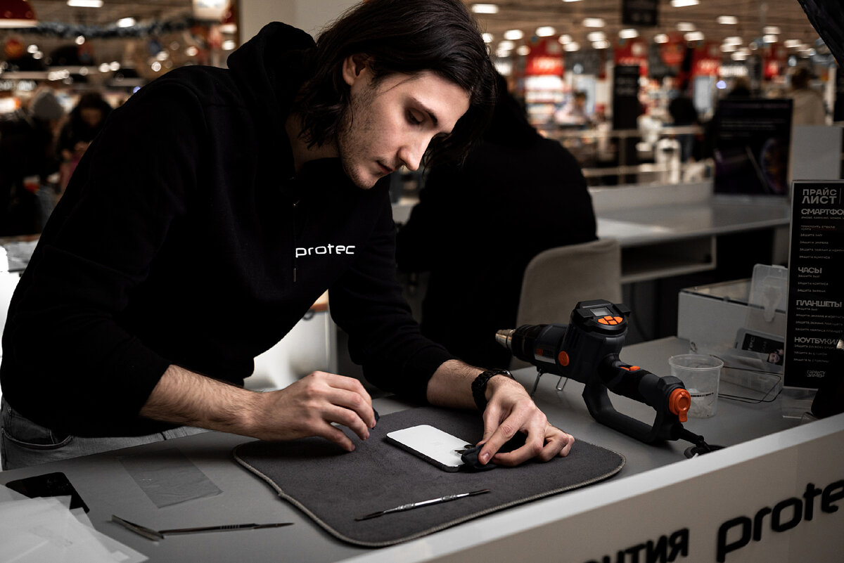 Это Стас, он клеет защиту на айфон 14 про в ТРЦ "Планета". Красноярск, 2023г.