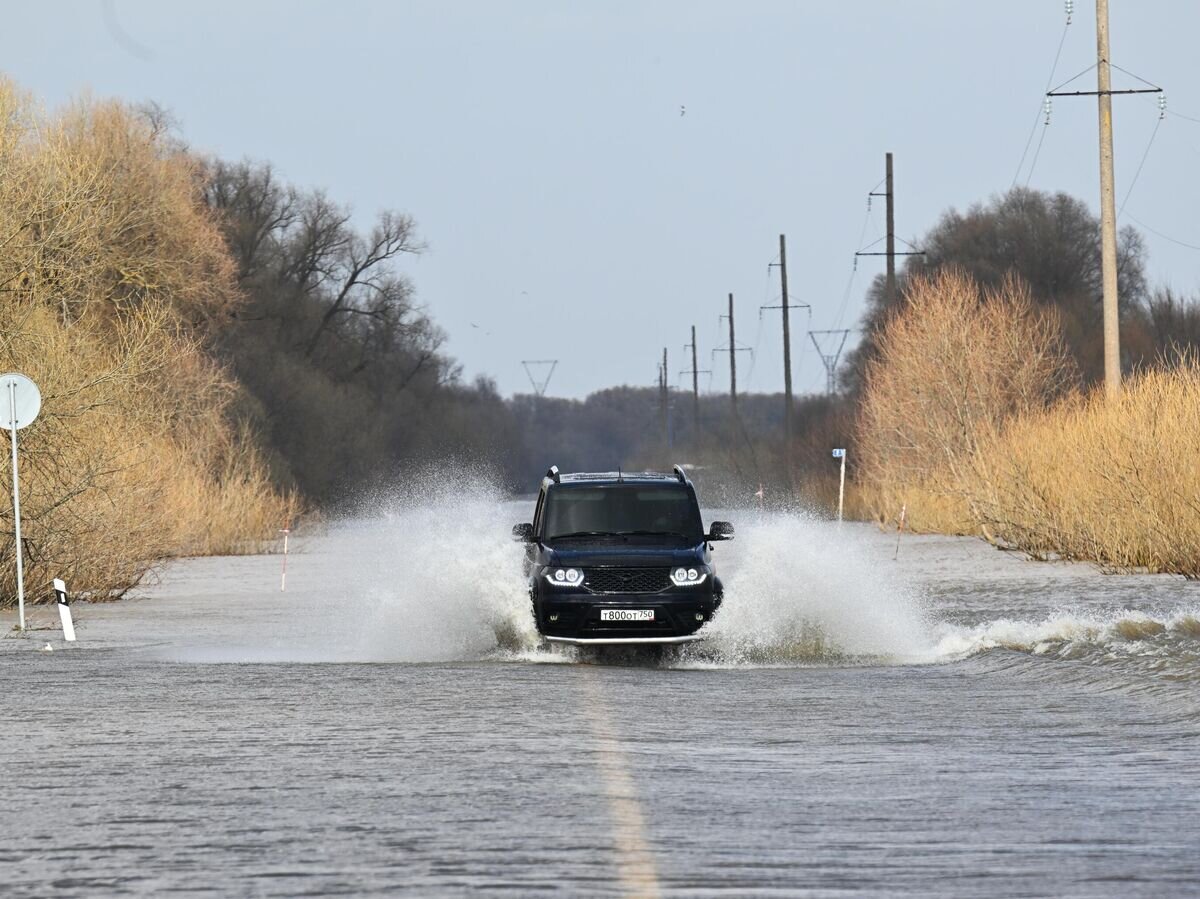    Автомобиль на подтопленной дороге в Луховицком районе Московской области© РИА Новости / Илья Питалев
