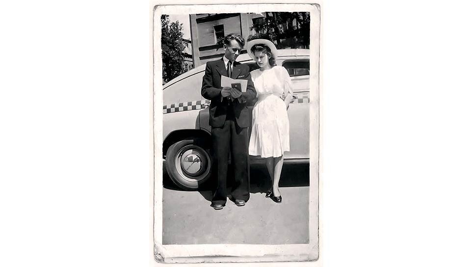 Так женились при Сталине. Новая советская семья фотографируется со свидетельством о браке, видимо, на выходе из ЗАГСа. Свадебный автомобиль - таксомотор "Победа" ГАЗ-М20, наверняка взятый, чтобы доехать от дома до ЗАГСа, а потом - домой или в ресторан. На обратной стороне фотографии есть подпись: 26 июня 1949 года. Свои имена новобрачные в подписи не увековечили.