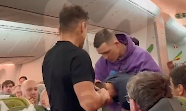    Боксеры помогают успокоить буйного пассажира.Скриншот видео Mash