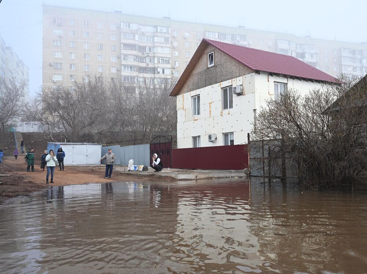    Местные жители на затопленной улице в микрорайоне Форштадт в Оренбурге© РИА Новости / Максим Богодвид