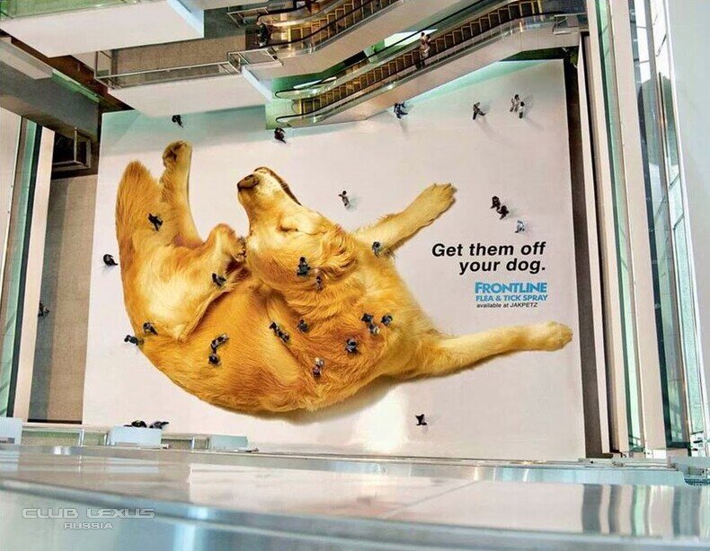 На изображении рекламный баннер FRONTLINE, представляющий средство от блох и клещей для собак. Баннер показывает огромное изображение собаки в позе на спине, а люди, которые ходят по такой рекламе, наглядно демонстрируют частую проблем собак.