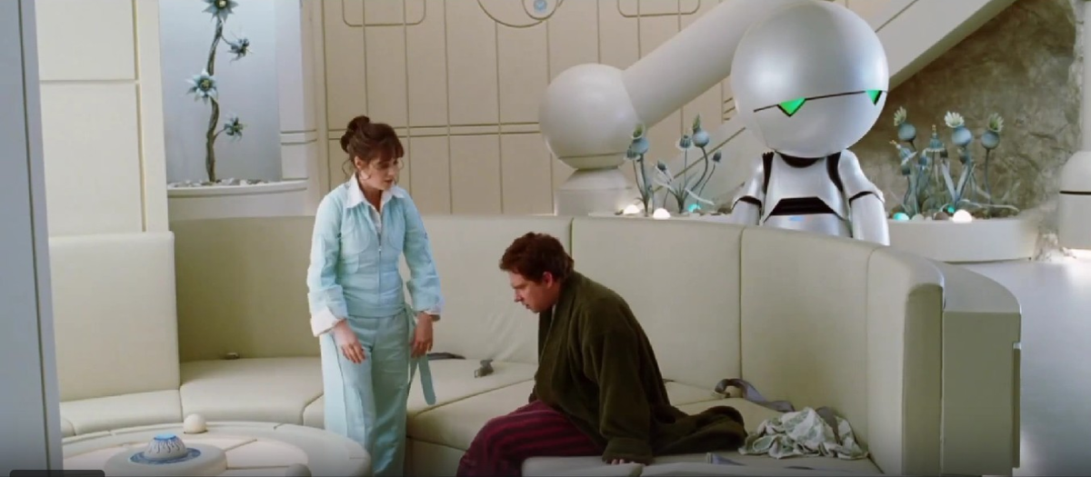 Центральное место в интерьере занимает полукруглый минималистичный диван. Кадр из фильма «Автостопом по галактике» (2005).