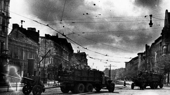 «Studebaker US6 2.5-ton 6×6» Красной Армии с 76-мм орудиями ЗиС-3 движутся по улице Берлина. Автор снимка — военный корреспондент газет «Защитник Отечества» 43-й Армии и «Боевой призыв» 61-й Армии Петр Сотников.