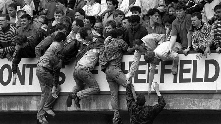 Болельщики "Ливерпуля" карабкаются на верхние трибуны, чтобы выбраться из давки. Фото: David Giles / RA Images/ Getty Images