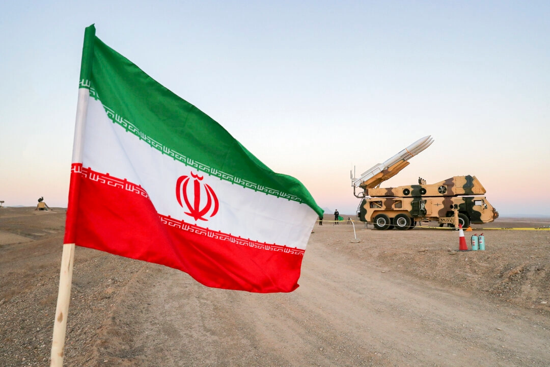 Иранский флаг изображен рядом с ракетой во время военных учений с участием подразделений ПВО Ирана в Иране, 19 октября 2020 года. (Агентство новостей Западной Азии через Reuters) 