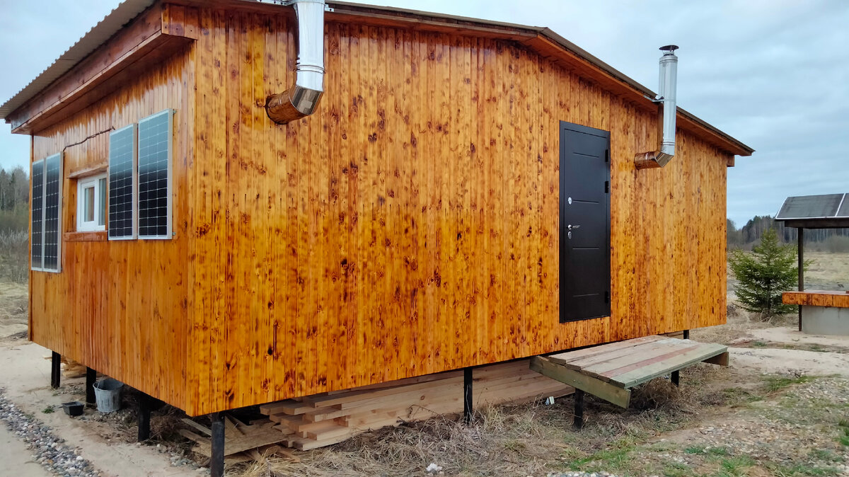 Под домик сложил часть досок из которых буду делать каркас сарайчика. Над дверью же предстоит сделать козырёк, а перед ней нормальное крыльцо, то крыльцо что делал, оно временное и сделано из всякого хлама, чтоб можно было просто войти в дом, так как дверь над уровнем земли достаточно высоко расположена