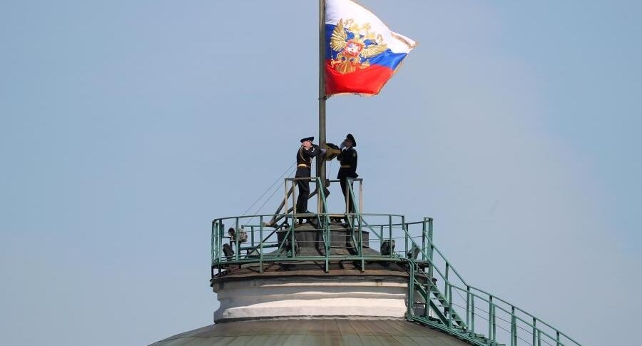    Солдаты Президентского полка поднимают штандарт президента РФ над куполом Сенатского дворца Московского Кремля.