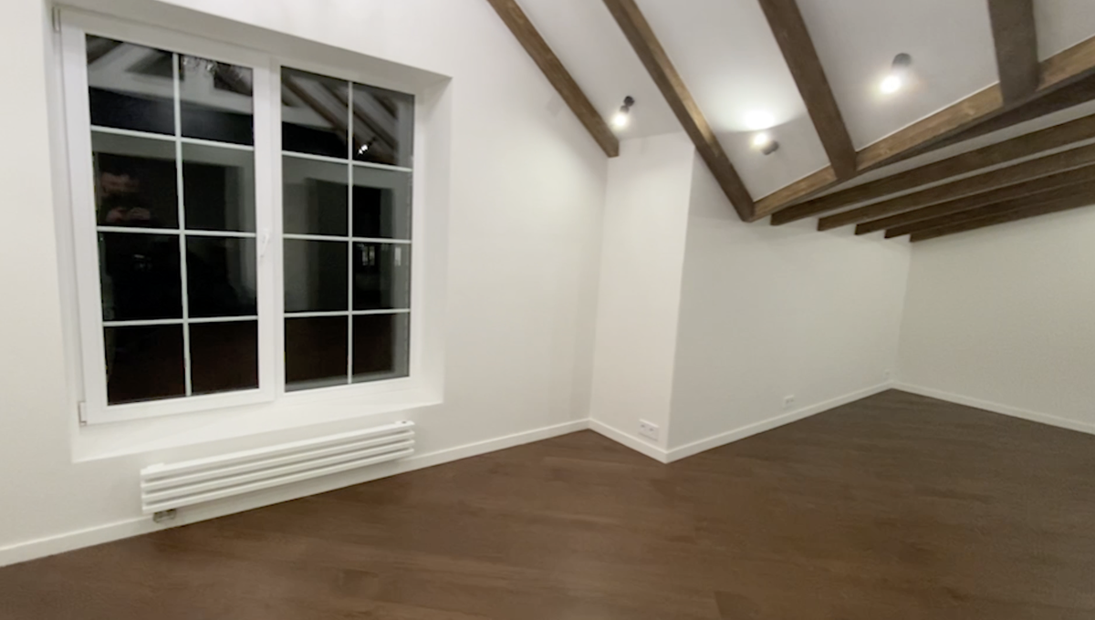 Белый гипсокартонный потолок, стропила коричневого цвета - нарощенные и выполняют декоративную функцию