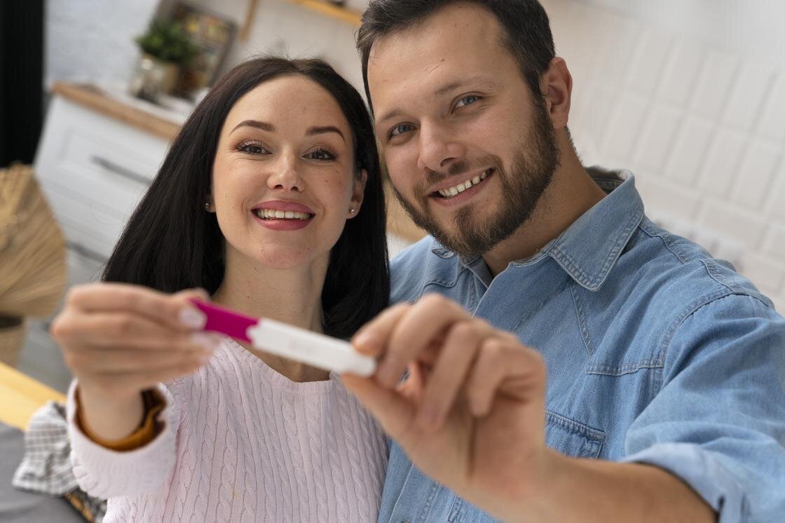    Пара держит в руках тест на беременность:Freepik