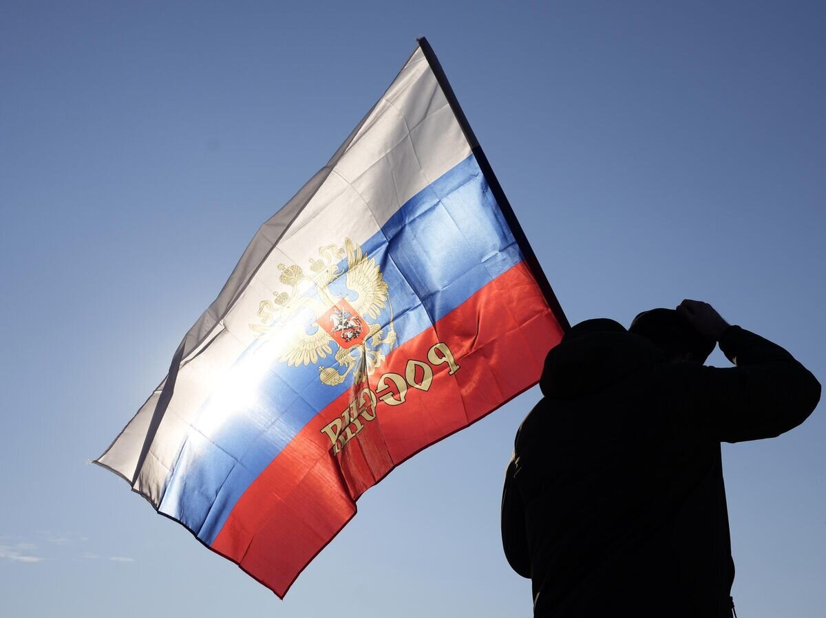    Мужчина с российским флагом© AP Photo / Darko Vojinovic
