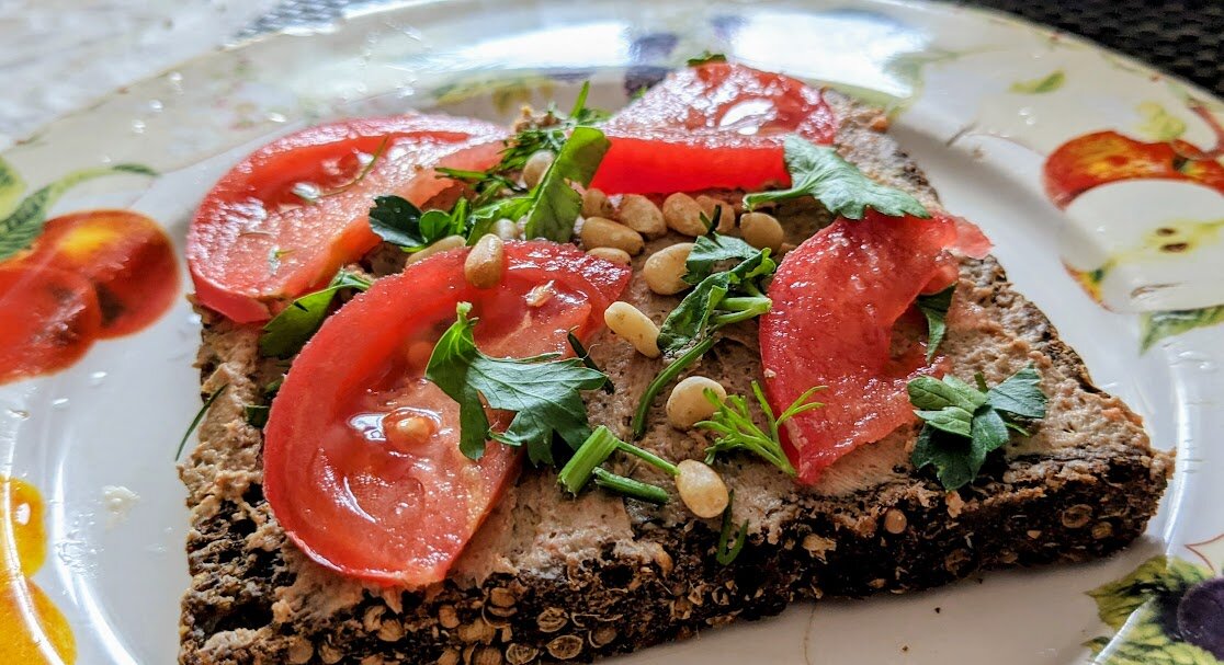 Цельнозерновой тост с паштетом из тофу, помидором, рукколой и кедровыми орехами. Фото автора
