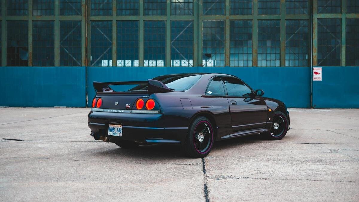    На фоне здания стоит фиолетовое авто с тонированными стеклами:Pexels/Erik Mclean