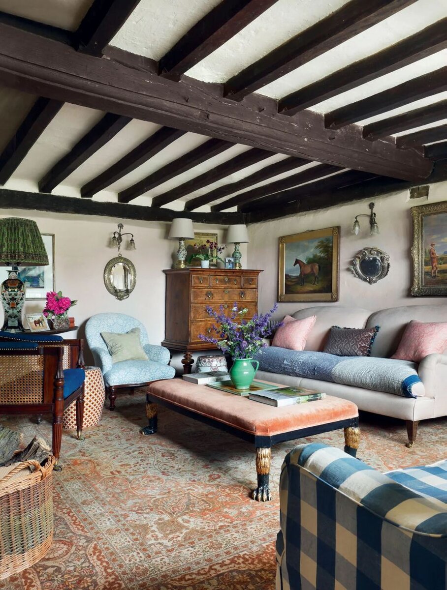 Под этим большим ковром в гостиной скрывается старый кирпичный пол. Кресло, два дивана и подставка для ног (обратите внимание, какие потрясающие у нее ножки в виде звериных лап) — из разных десятилетий. Изначально они выглядели иначе. Их отреставрировали и обшили ретро-тканью