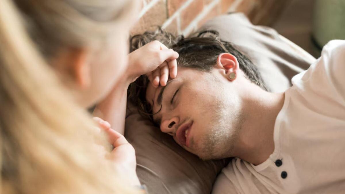    Девушка прикасается к спящему мужчине:Freepik