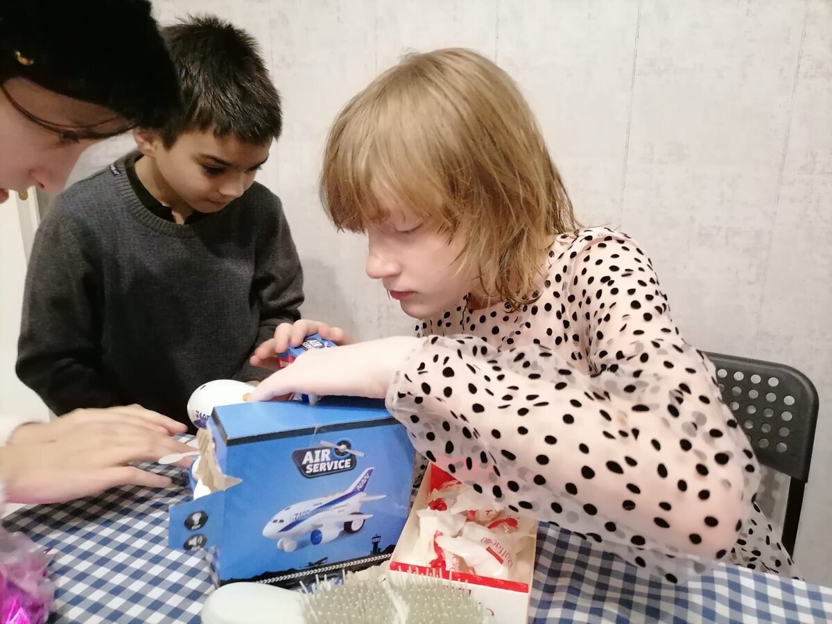 День рождения Светы. Дети помогают открыть упаковку с подарком