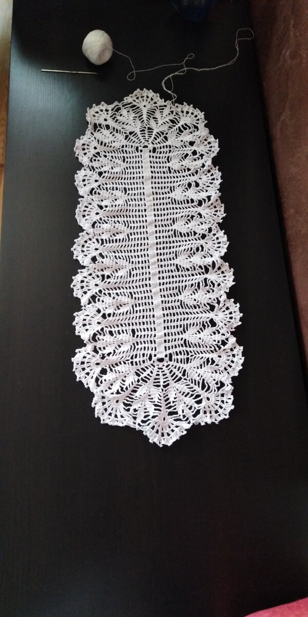 Салфетка ещё без крахмала и глажки. Это не тот стол, для которого я вязала, это наш, под телевизор, положила на него салфетку на примерку. Добавлю ещё несколько ажурных рядов (на схеме их нет), и готово. 