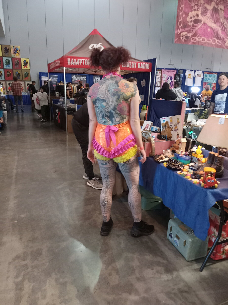 Одна из посетительниц американского фестиваля татуировок с тату во всю спину. Март 2024. Фото автора статьи The ЖурнальчиК.  