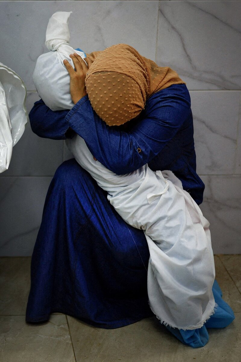 Палестинская женщина обнимает тело своей племянницы Мохаммед Салем , Палестина, Reuters.