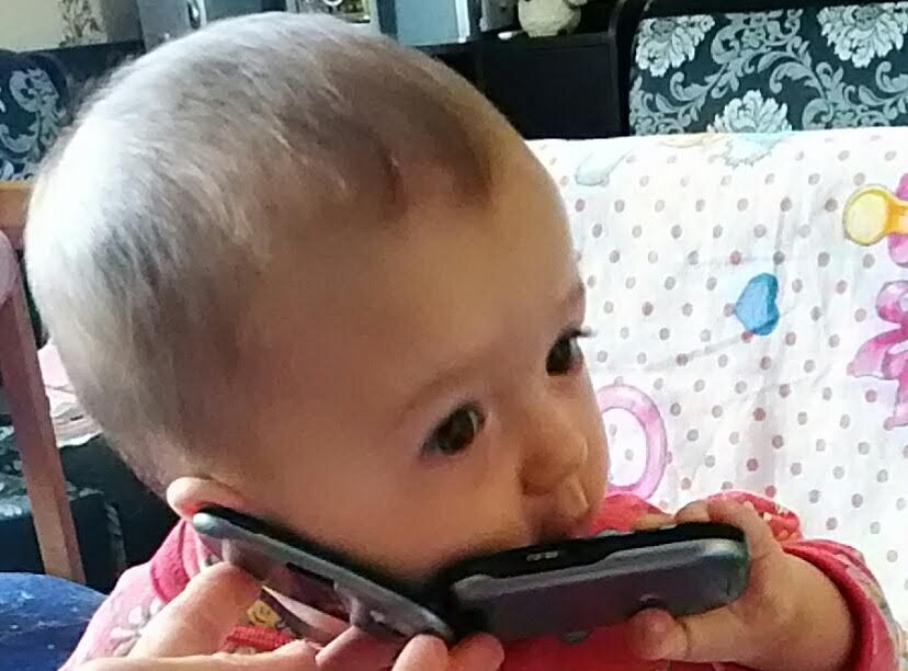 Катруся (6 мес) "звонит" папе. Фото от 21 июля 2019 г