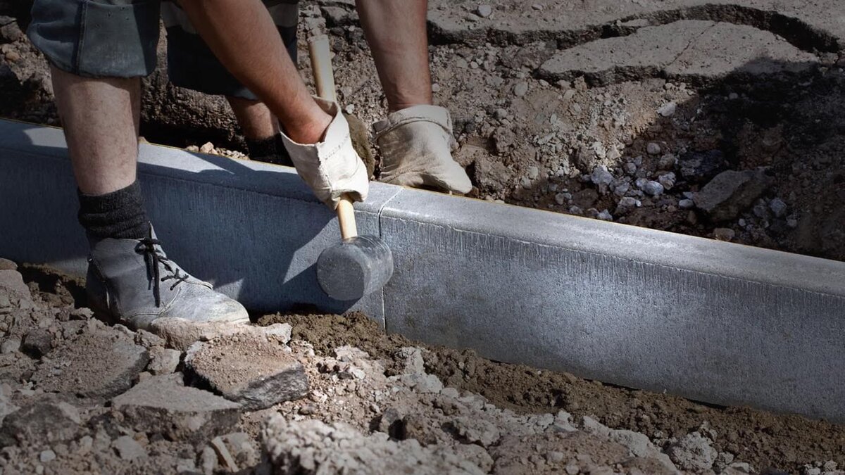 Незаменимый специалист из Средней Азии монтирует жизненно необходимый Москве бордюр