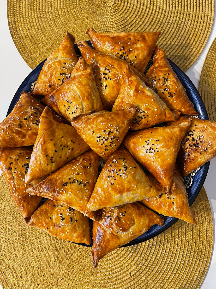 Тесто для самсы всегда пресное, без дрожжей. Может быть и совсем простым – мука, вода, соль, и с добавлением жира, лучше всего – растопленного курдючного. В современных городских условиях бараний жир часто заменяют сливочным маслом. Жир  промазывают  тонко раскатанный пласт теста, который затем сворачивают в тугой рулет, охлаждают и нарезают на порционные куски. Их раскатывают в лепешки, кладут фарш и формируют треугольную самсу. Самса из такого ложно-слоеного теста очень вкусна!

Начинка для самсы всегда сырая, и не важно, мясо ли это, тыква или зелень. Мясо, чаще всего – баранина, смешивается с мелко нарезанным луком, приправляется солью, перцем и специями. Самса будет особенно вкусной, если в начинку добавлены несколько кусочков курдючного жира.

И, разумеется, самая правильная самса – с пылу, с жару!

 ИНГРЕДИЕНТЫ НА 16 ПОРЦИЙ
Для пресного теста:
питьевая вода – 250 мл
соль – 1 ч. л.
мука – 500 г
растительное масло – 1 ст. л.
Для слоеного теста:
сливочное масло – 200–250 г + для смазывания
питьевая вода – 250 мл
яйцо – 1 шт.
мука – 640 г
соль – 1/2 ч. л.
крахмал для раскатывания теста, 
желток и молоко– для смазки 
по вкусу черный тмин или кунжут для посыпания самсы –

Для фарша:
мякоть баранины с жирком– 600-700 г
репчатый лук – 2 шт.
зира, соль, свежемолотый черный перец – по вкусу