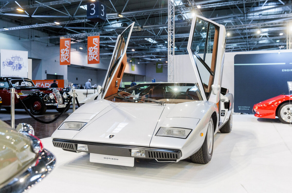    Говорят, что этот Lamborghini Countach был продан за миллион евро. Это очень ранняя машина в версии LP400 «Periscopio» — без дополнительных спойлеров и накладок, зато с крохотным отверстием в крыше, за которое её и прозвали «перископом». Чистый клиновидный кузов без спойлеров и накладок ближе всего к оригинальной задумке великого [Марчелло Гандини](https://motor.ru/stories/marcello-gandini.htm). Хотя видеть такую машину в цвете «серебристый металлик» непривычно.   
Alex Muchnik / Messe Essen
