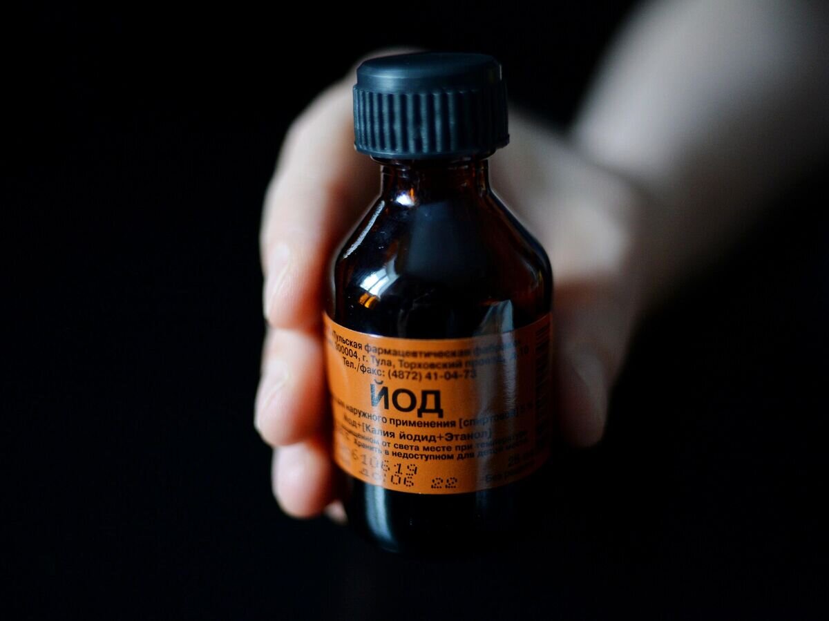    Человек держит в руках флакон с раствором йода© РИА Новости / Павел Лисицын