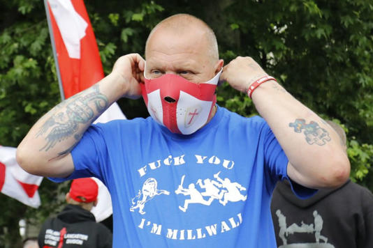 Мужчина в маске с флагом Святого Георгия на акции протеста Лиги защиты Англии в Лондоне, 2017 год.