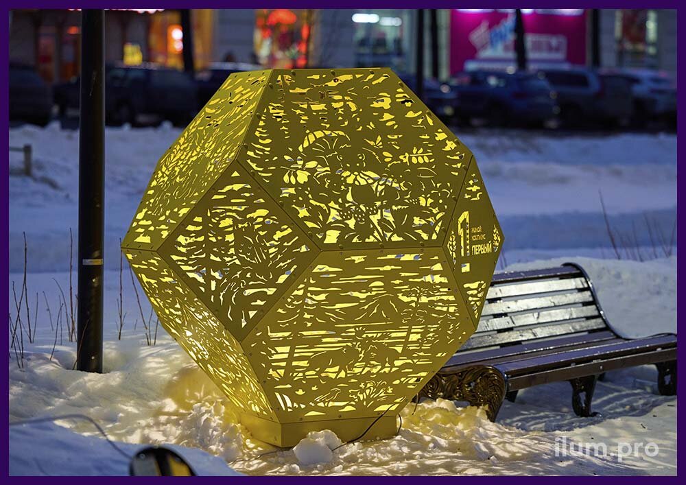 Большой, жёлтый светильник в форме перфорированного многогранника с изображениями животных