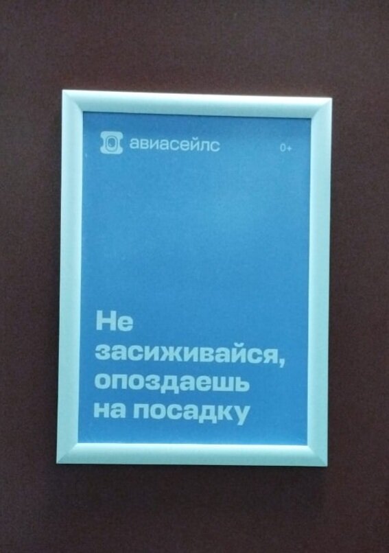 реклама Авиасейлс на двери кабинки туалета в аэропорту Калининграда