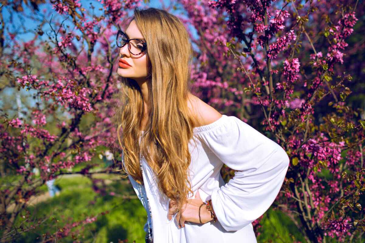    Close up spring summer portrait of stunning young woman with natural amazing long hairs and beauty face, wearing clear glasses and looking on camera, sunny colors. Карина Жук