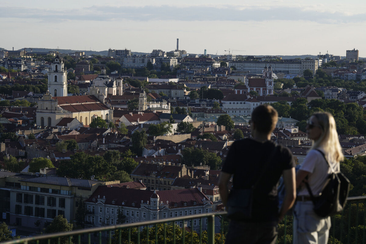 Люди наслаждаются видом на город в Вильнюсе, Литва // AP Photo / Pavel Golovkin