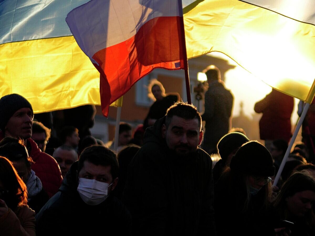    Люди с флагами Польши и Украины в Варшаве© AP Photo / Petr David Josek