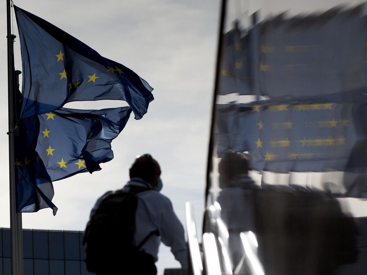    Мужчина проходит мимо флагов Европейского союза в Брюсселе© AP Photo / Virginia Mayo