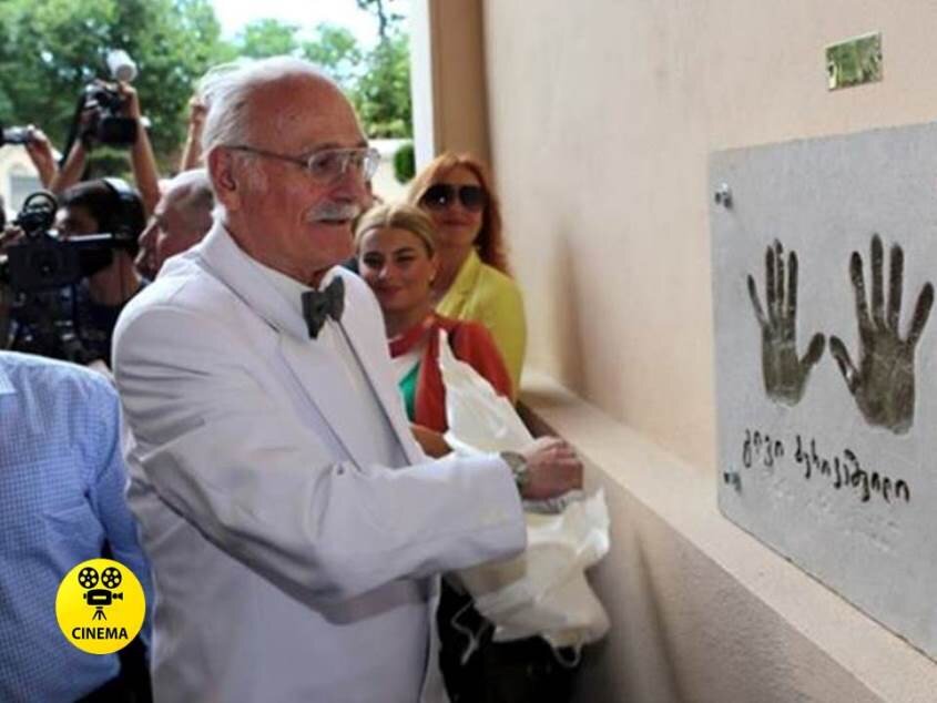 Кахи Кавсадзе возле памятной доски на стене Дворца искусств в Тбилиси в 2013 году.