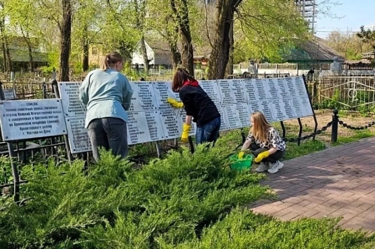    Волонтеры помогают убирать территорию.