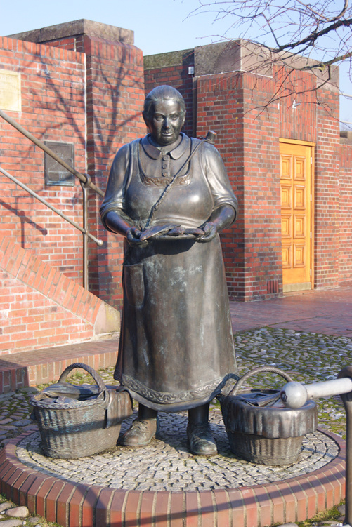 Скульптура рыбачки из Фризии. Здесь она полностью обутая продаёт рыбу // Источник: ferien-in-ditzum.de