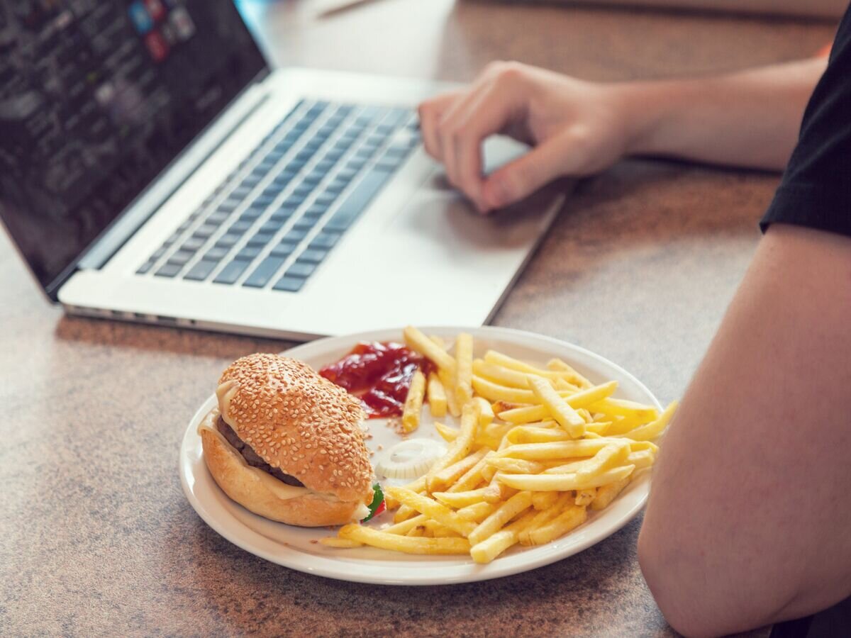    Студент обедает за компьютером© Fotolia / alexandre zveiger