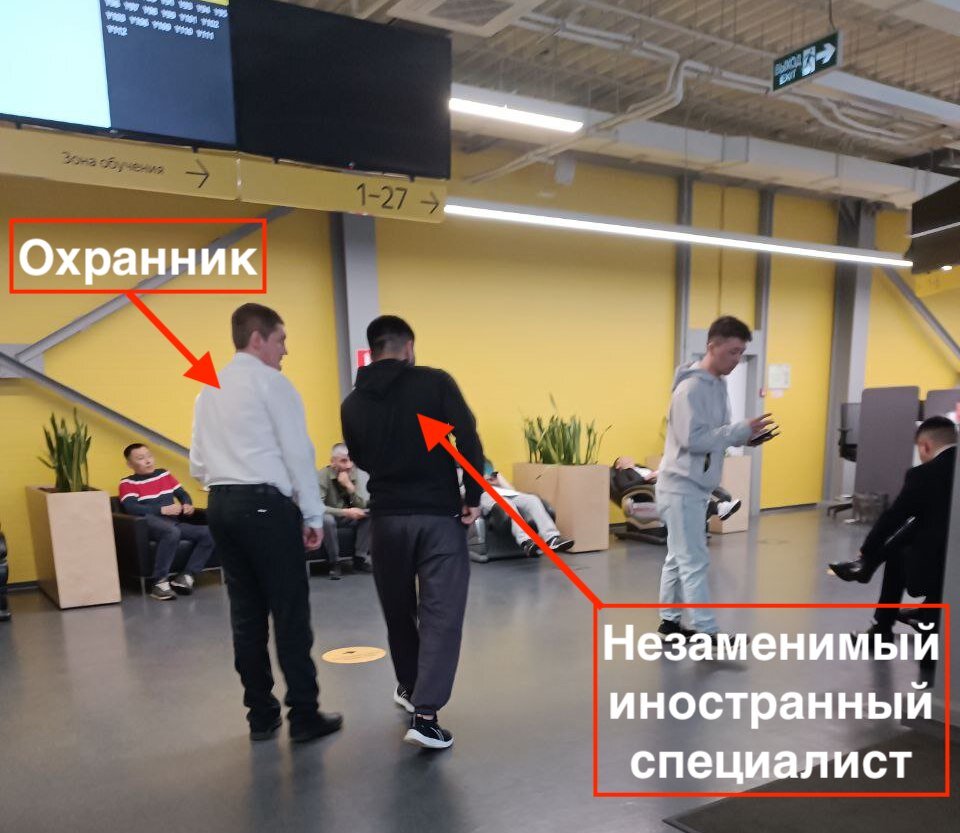 Охрана проводит персональную экскурсию мигранту, так как он не понимает на какое табло нужно посмотреть и куда его потом пригласят