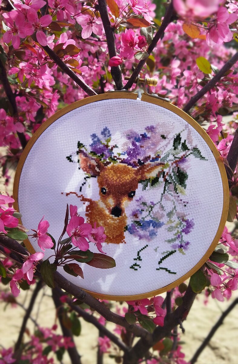 Оленёнок спрятался в  цветах декоративной яблони