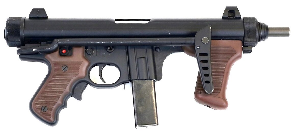 Пистолет-пулемет М12 со сложенным прикладом. Обратите внимание на кнопочный регулятор выбора режима ведения огня.