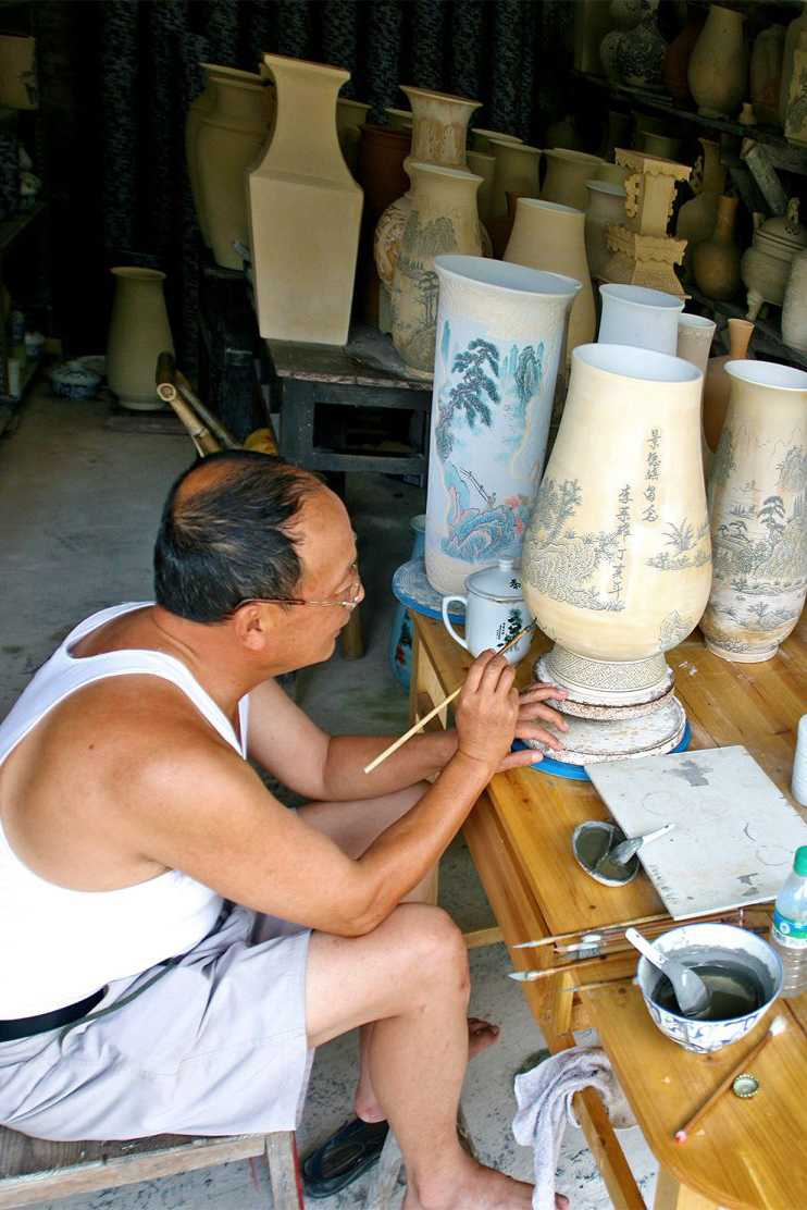 Мастер расписывает вазу в мастерской Цзиндэчжень