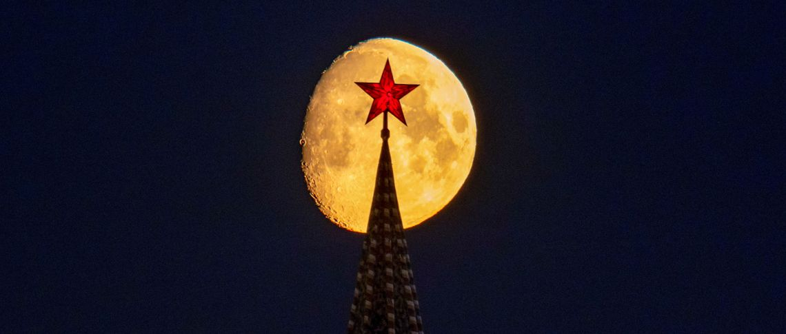Луна восходит за башней Кремля и красной звездой на ее вершине. Фотоальянс/Рейтер | Марина Лысцева.