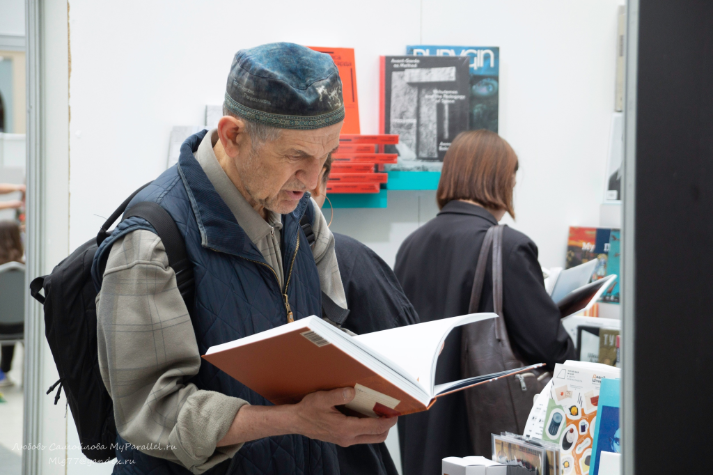    Мужчина возле Музея еврейской толерантности читает книгу